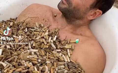 Se bañó con 400 mil colillas de cigarrillo para concientizar sobre obre la contaminación