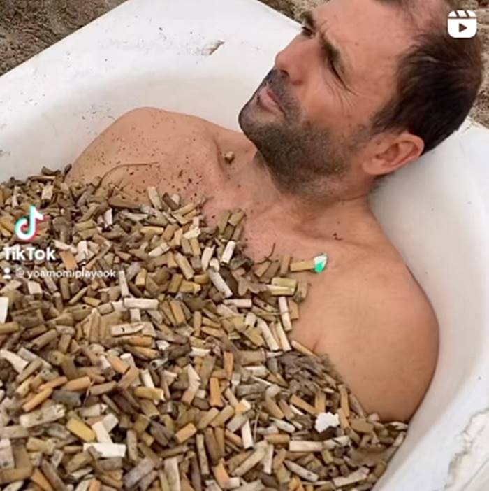 Se bañó con 400 mil colillas de cigarrillo para concientizar sobre obre la contaminación